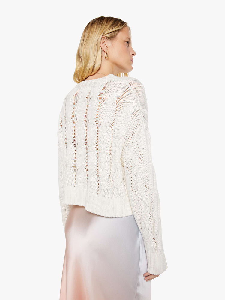 Back view of a woman in a  top is designed with a crewneck, long sleeves, ribbed hems and a slightly oversized fit.