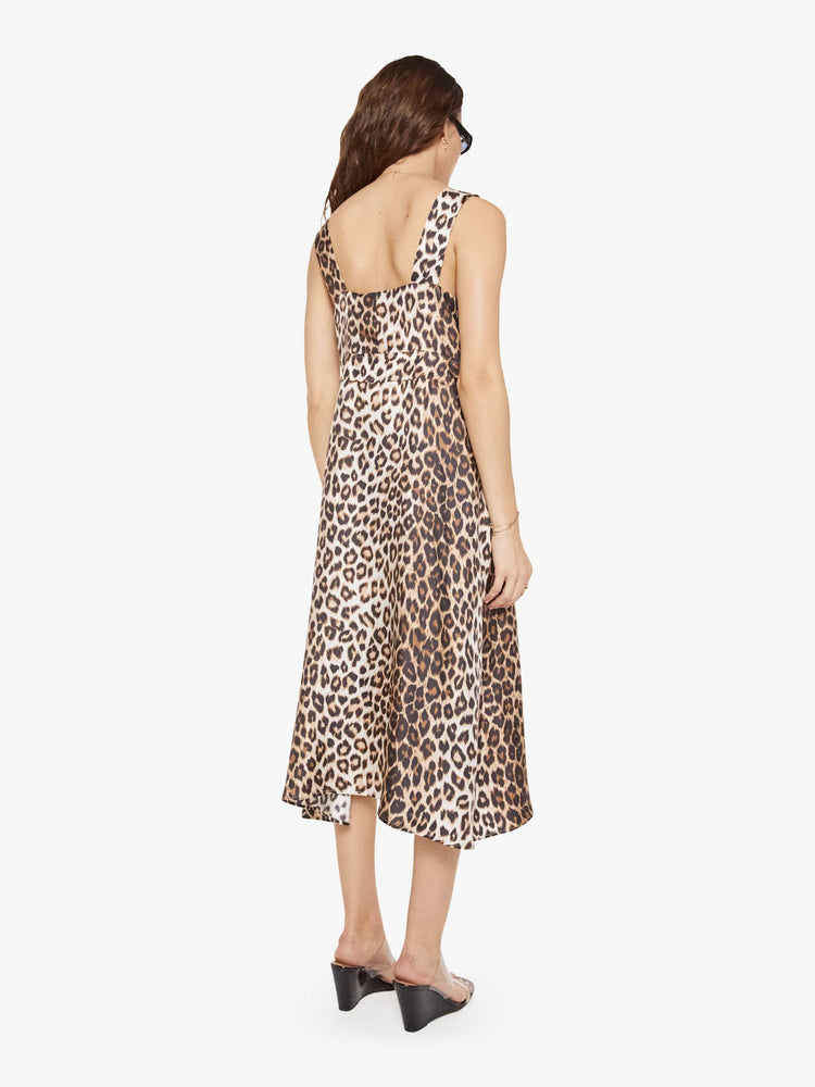 Back view of a woman in a cheetah print dress and features wide straps, a scoop neck, black buttons down the front and a calf-length hem.