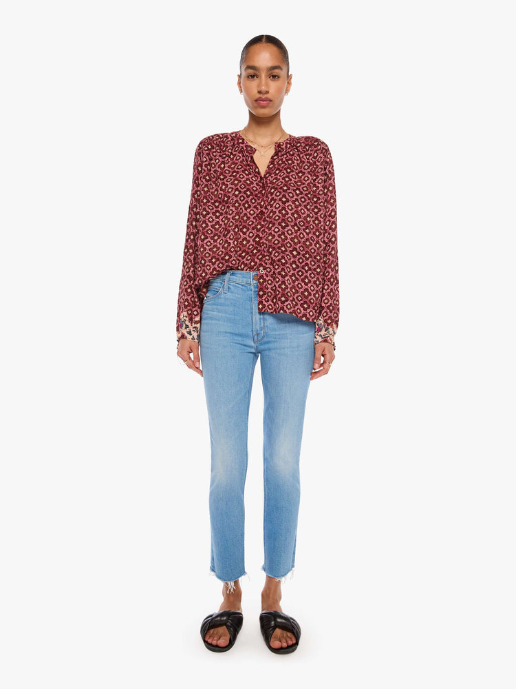 Full body view of a woman in a brick red mosaic print with a crew neck, long balloon sleeves and ruffles throughout for a flowy fit.