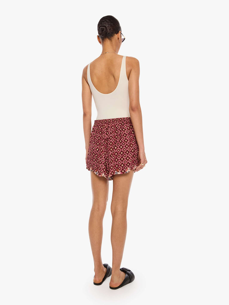 Back view of a woman in shorts with an elastic waist, side slit pockets, a slightly curved hem and loose, flowy fit.
