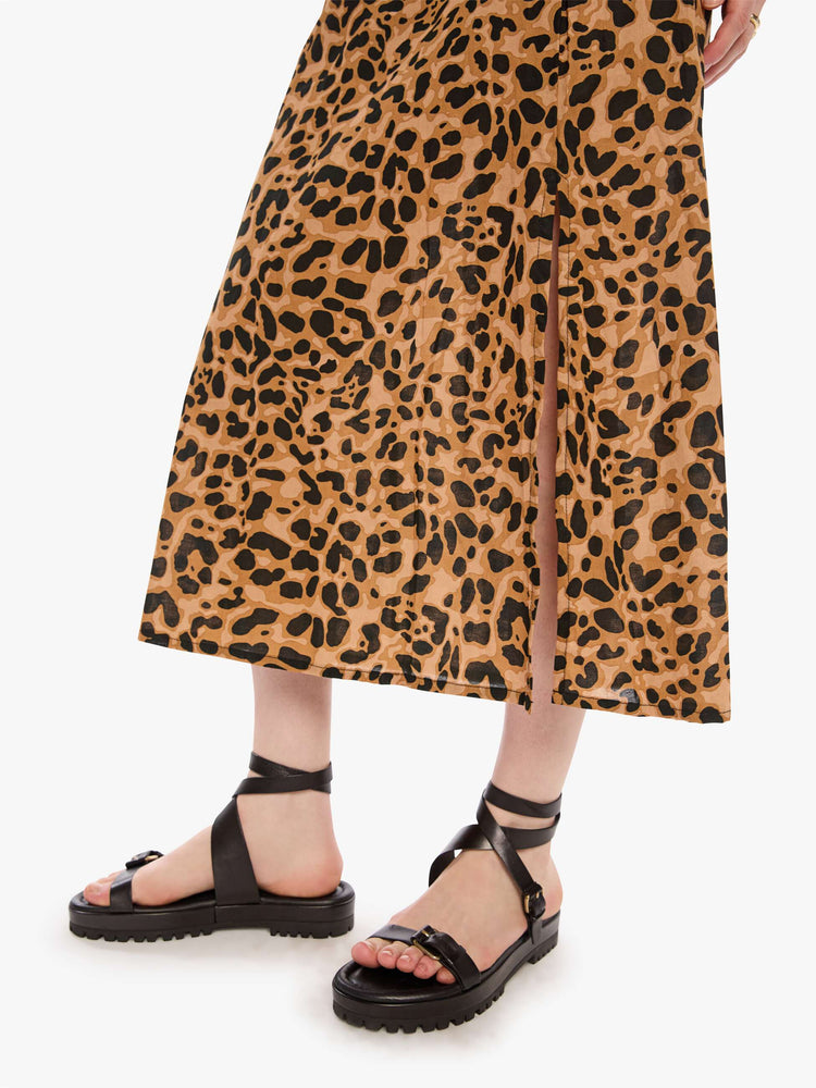 Hem view of a woman in a leopard skirt with a high rise, calf-length hem and a loose, flowy fit.