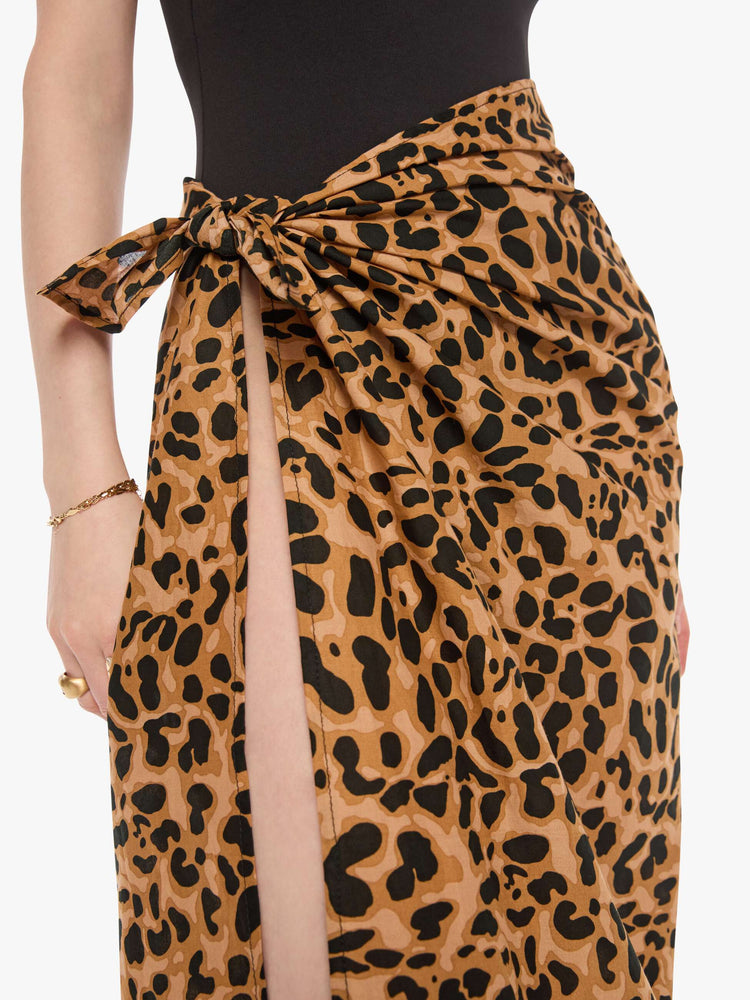 Close up view of a woman wearing a leopard print square scarf like a wrapped skirt.