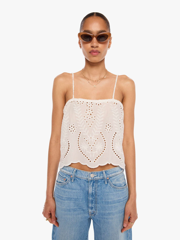 Front view of a woman in an off-white with delicate embroidery, eyelet details and a scalloped hem, the Fern cami has a square neck, spaghetti straps and a cropped, boxy fit.