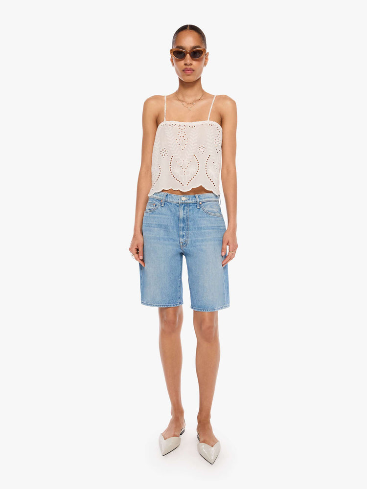 Full body view of a woman in an off-white with delicate embroidery, eyelet details and a scalloped hem, the Fern cami has a square neck, spaghetti straps and a cropped, boxy fit.