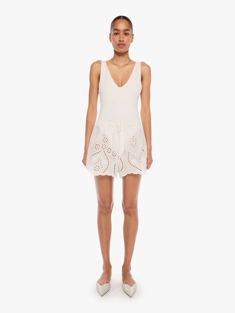 Front view of a woman in a white with an elastic high waist short, side slit pockets, a slightly curved hem and a loose, flowy fit.