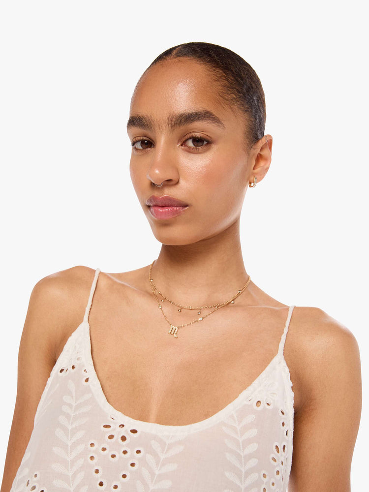 Close up view of a woman in a dress with a scoop neck, thin spaghetti straps, an ankle-length hem and a loose, flowy fit.