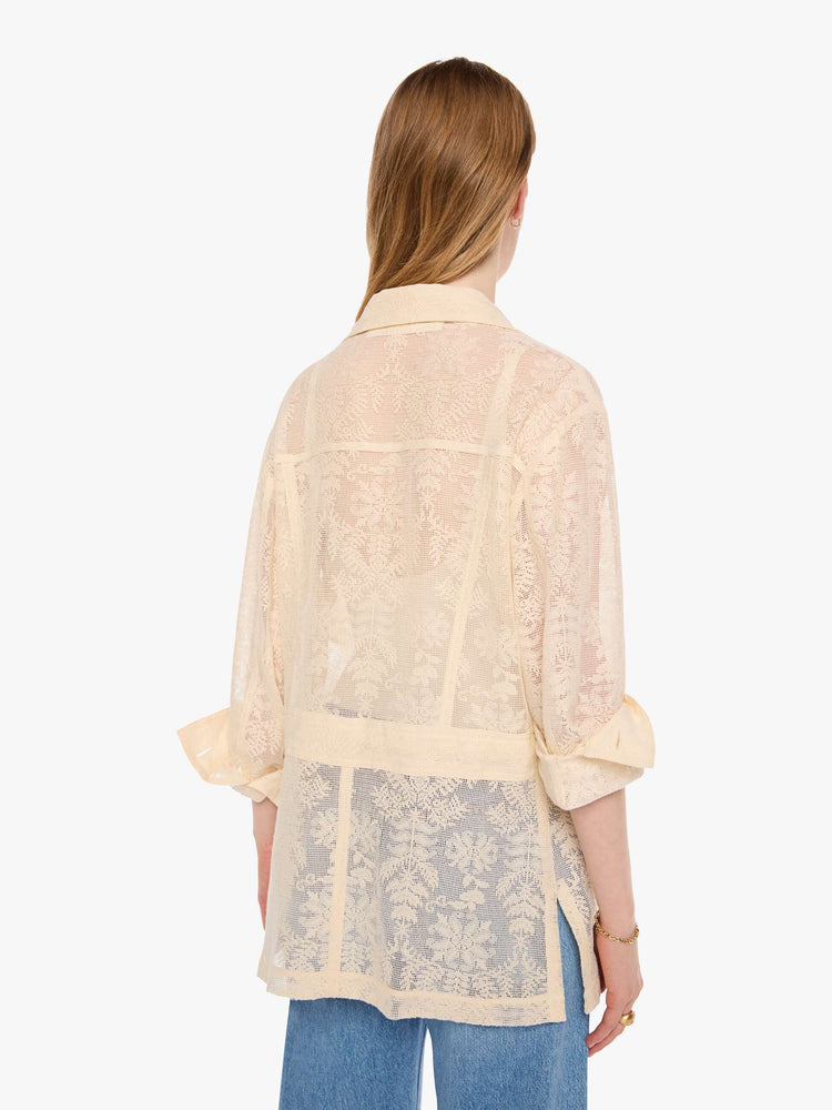 Back view of a woman in cream jacket with brown buttons, and features oversized patch pockets, 3/4-length sleeves, an extra-long hem and a boxy fit.