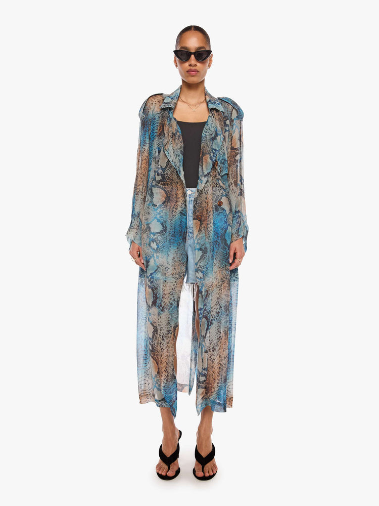 Front view of a woman in a blue, cream, brown and black oversized snake print jacket and features a notched collar, long sleeves and an ankle-length hem.