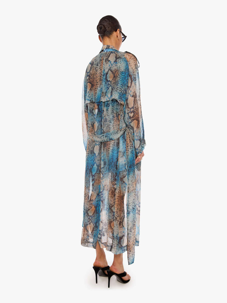 Back view of a woman in a blue, cream, brown and black oversized snake print jacket and features a notched collar, long sleeves and an ankle-length hem.