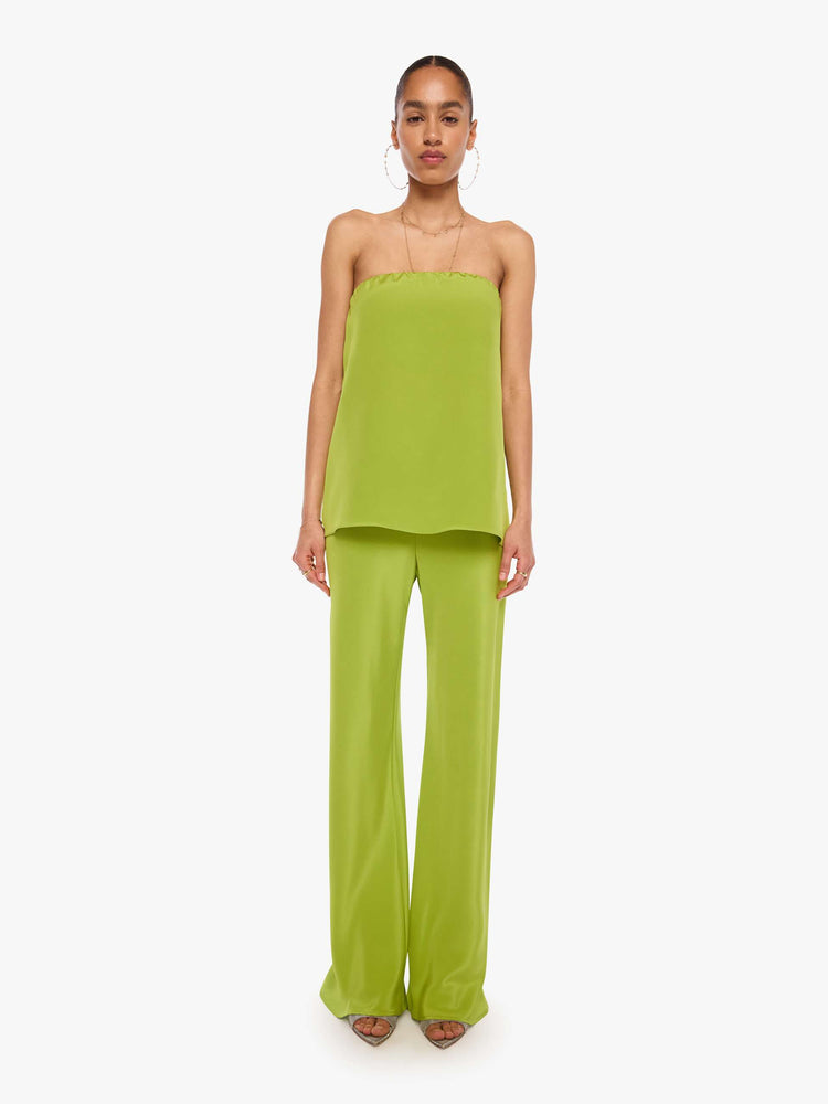 Full body view of a woman in a green strapless top with a loose, flowy fit.