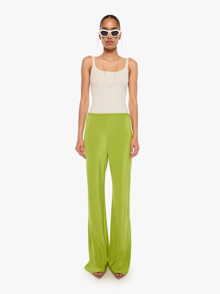 Front view of a woman in a green pant with an elastic waistband, a loose leg and an extra-long hem.