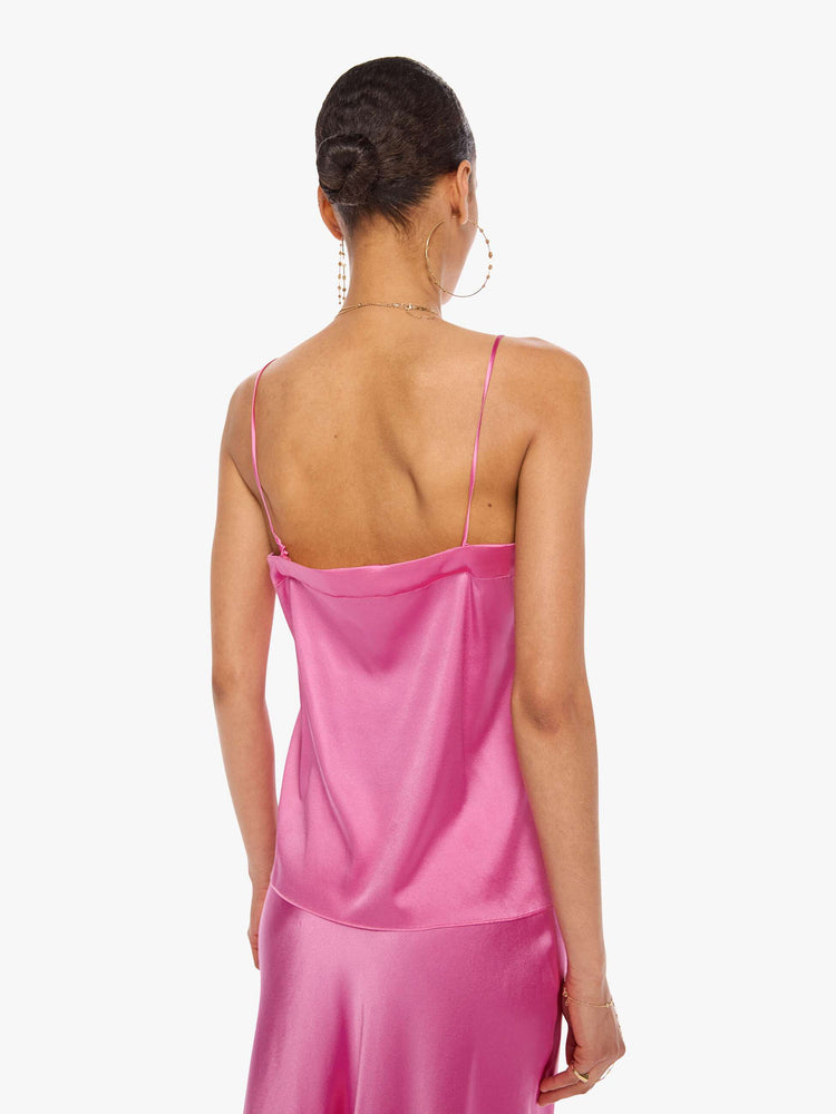 Back view of a woman in a pink cami with thin spaghetti straps, a lace-trimmed V-neck and a loose, flowy fit.