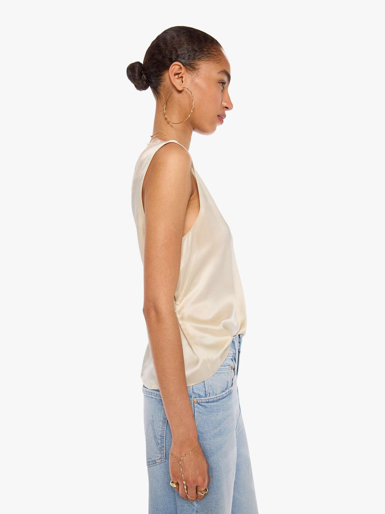 Side view of a woman in a tank is designed with a V-neck, thick straps and a loose fit.