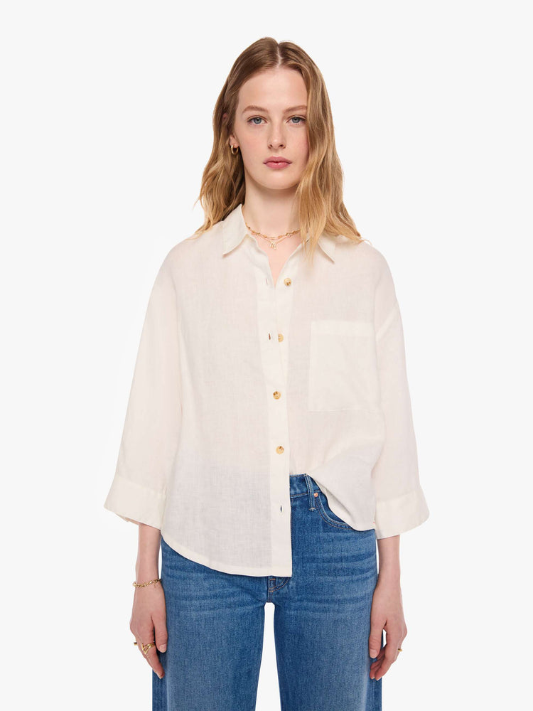 Front view of a woman in a shirt is a classic button-up with drop shoulders, cropped long sleeves and a patch pocket on the chest.