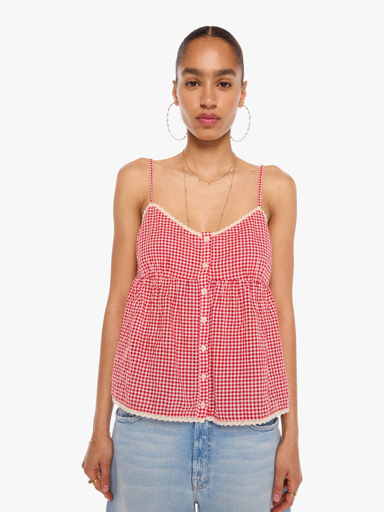 Front view of a woman in a red and off-white gingham thin spaghetti straps, a V-neck, gathered bodice and buttons down the front.
