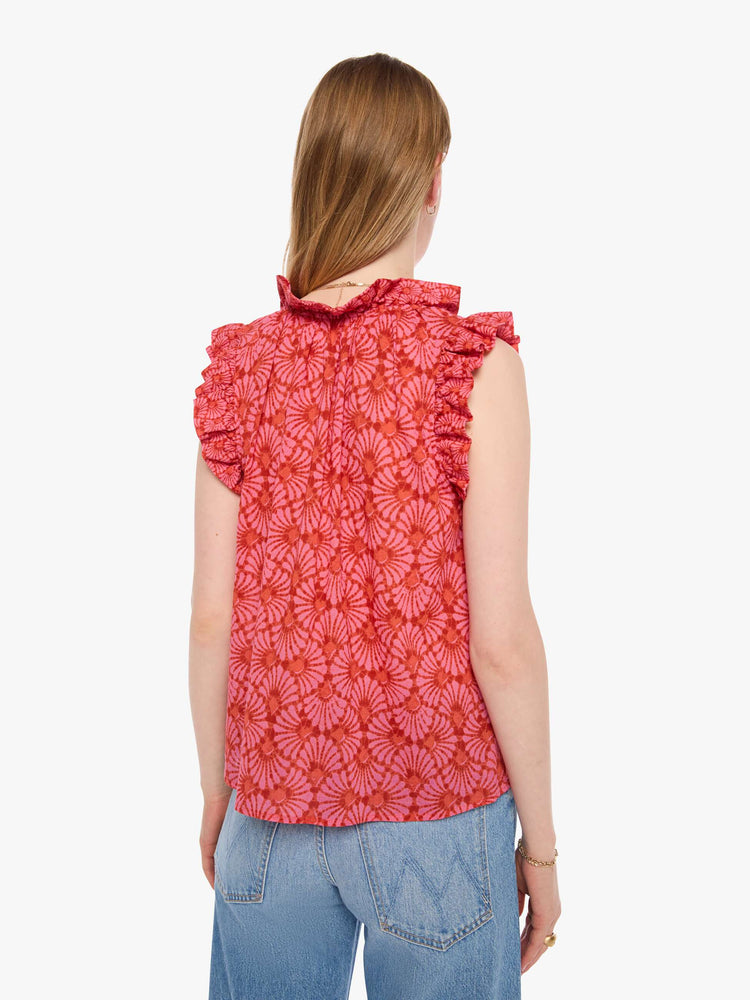 Back view of a woman in a vneck top pink and orange graphic print, and features short, ruffled sleeves and a boxy fit.