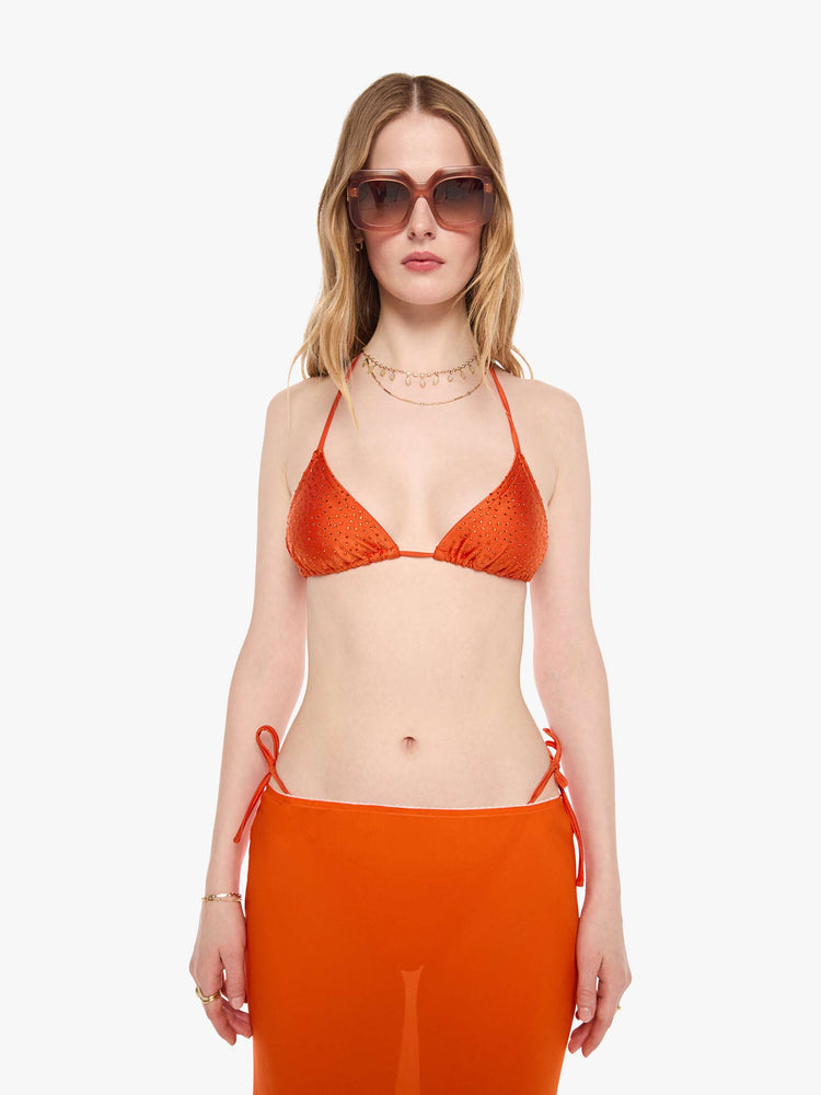 Front view of a woman in string bikini top from SPRWMN with decorative rhinestones throughout in orange, the bikini top has a triangle design and tie closures.