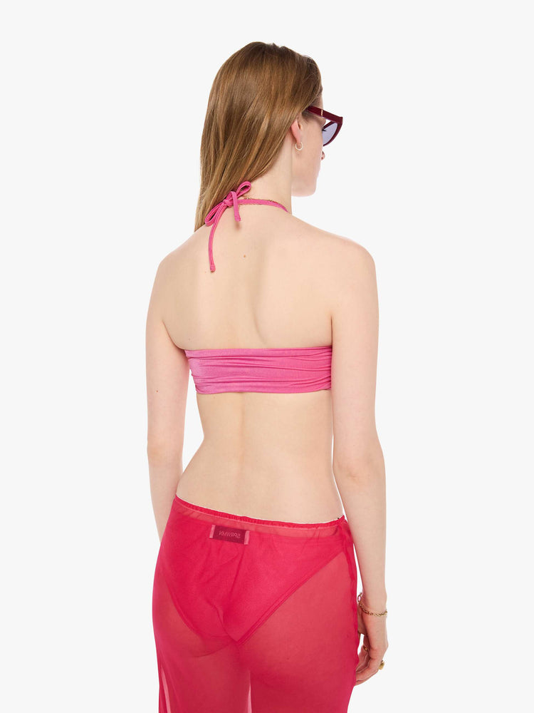 Back view of a woman in a pink bikini top from SPRWMN with an adjustable fit has a twisted bandeau design and removable straps.