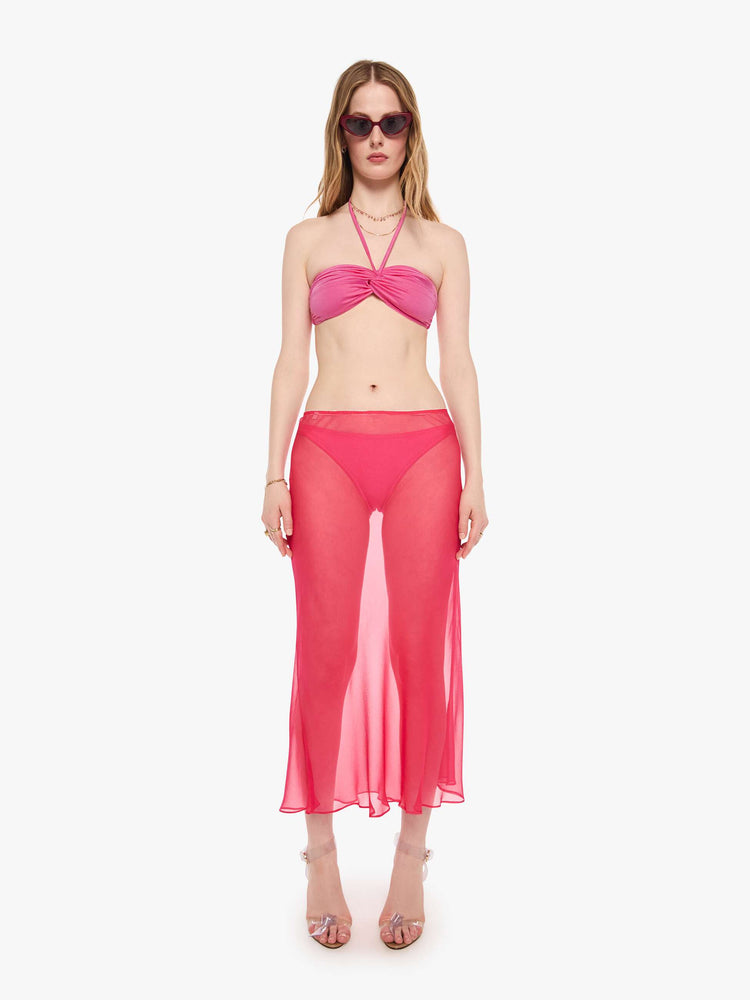 Full body view of a woman in a pink bikini top from SPRWMN with an adjustable fit has a twisted bandeau design and removable straps.