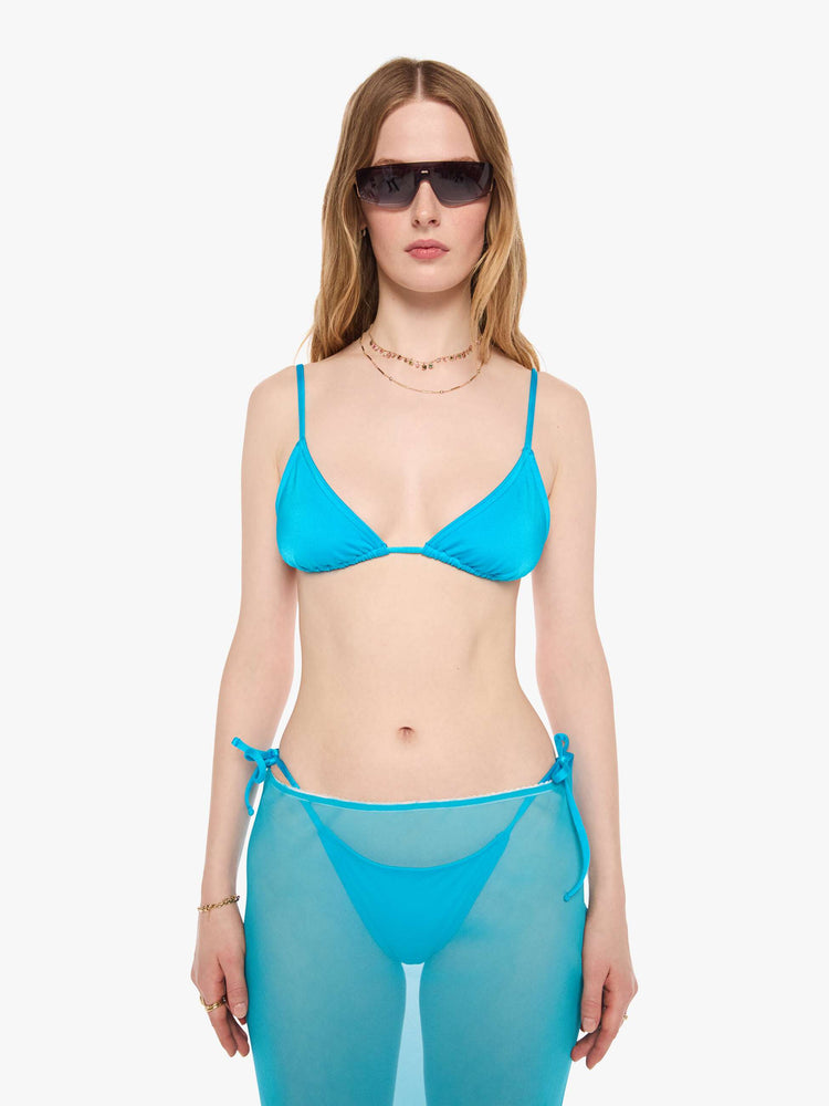 Front view of a woman in a string bikini top from SPRWMN designed in turquoise with a triangle design and tie closures.