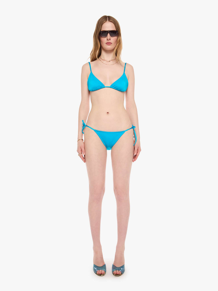 Front view of a woman in a string bikini bottom from SPRWMN designed in turquoise with a high rise and tie closures.