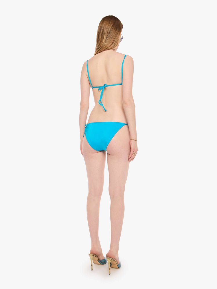 Back view of a woman in a string bikini bottom from SPRWMN designed in turquoise with a high rise and tie closures.