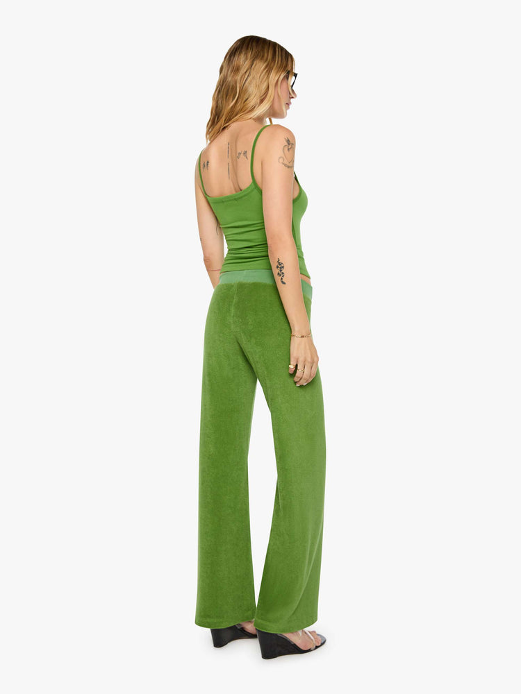 Back view of a woman in a green pants have a low rise, elastic waistband, loose leg and a cozy fit.