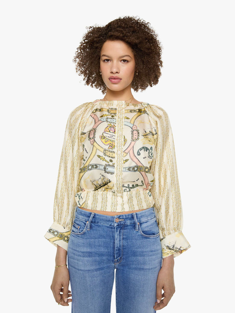 Front view of a woman in a stripe pattern with vintage-inspired graphics, and features a crewneck, long balloon sleeves and a slightly cropped fit.