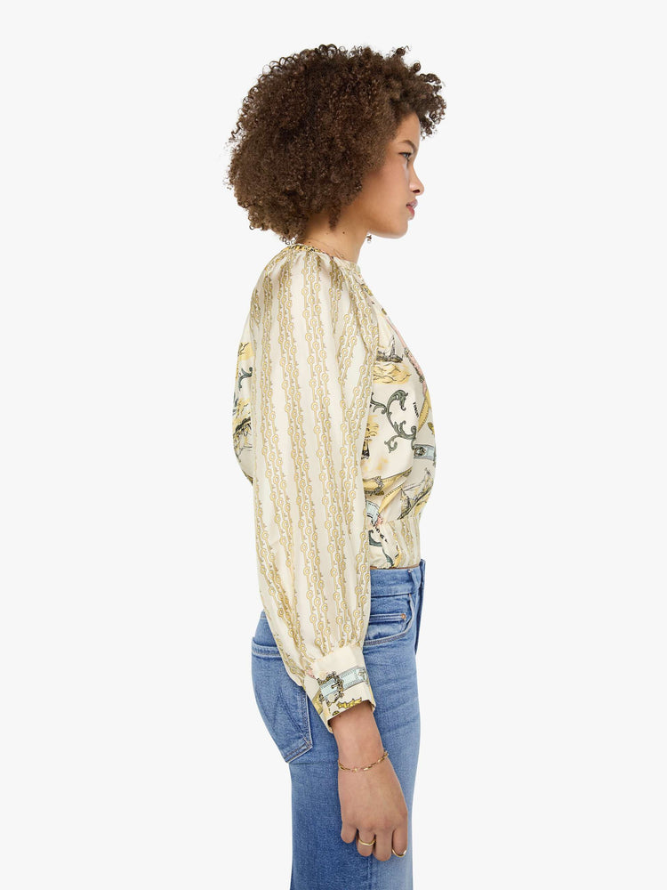 Side view of a woman in a stripe pattern with vintage-inspired graphics, and features a crewneck, long balloon sleeves and a slightly cropped fit.