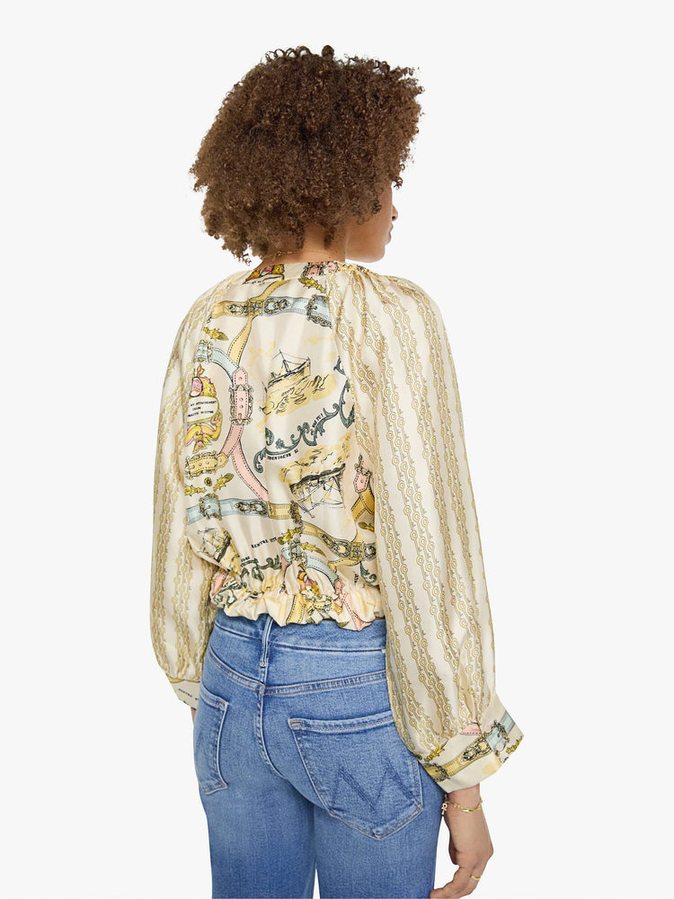 Back view of a woman in a stripe pattern with vintage-inspired graphics, and features a crewneck, long balloon sleeves and a slightly cropped fit.