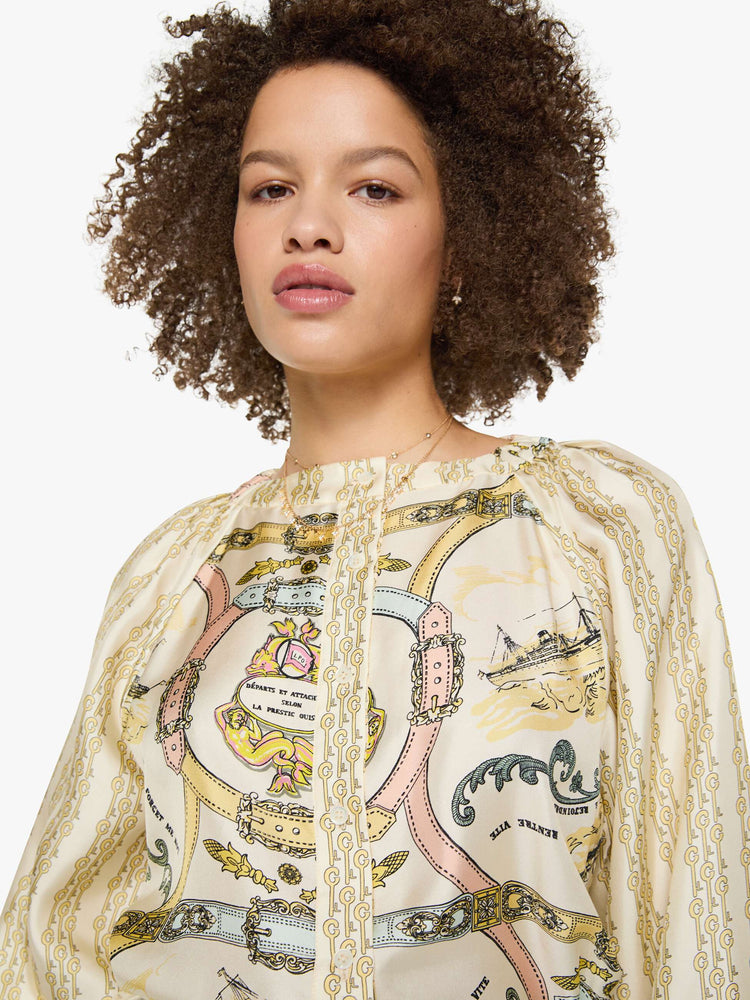 Close up view of a woman in a stripe pattern with vintage-inspired graphics, and features a crewneck, long balloon sleeves and a slightly cropped fit.