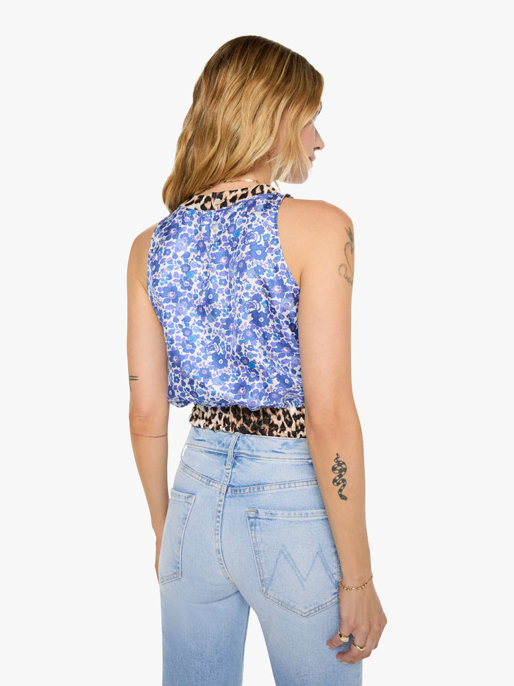 Back view of a woman in blue and white floral print with cheetah print trim shirt with crewneck, wide, gathered hem and slightly cropped fit.