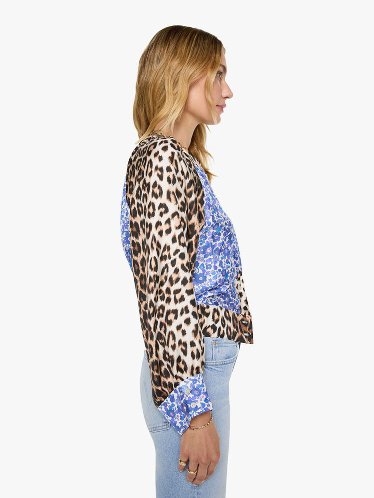 Side view of a woman in blue and white floral print with cheetah print trim and sleeves shirt with a crewneck, long balloon sleeves and a slightly cropped fit.
