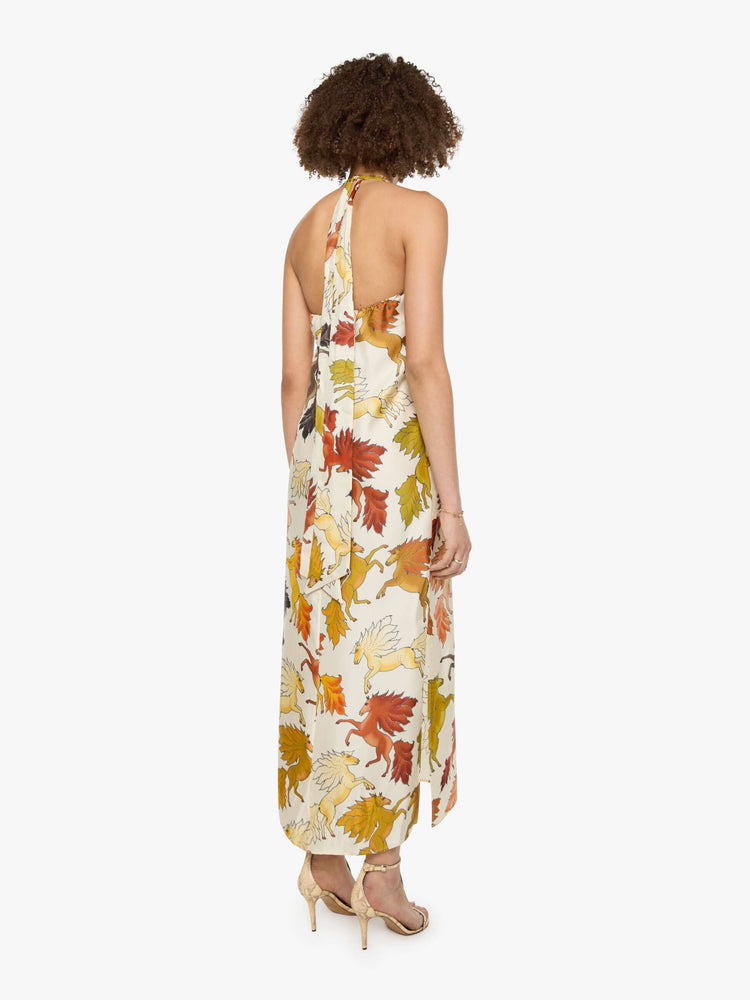 Back view of a woman in prints with classic silhouettes, featuring a high halter neck, semi-fitted waist and a flowy ankle-length skirt