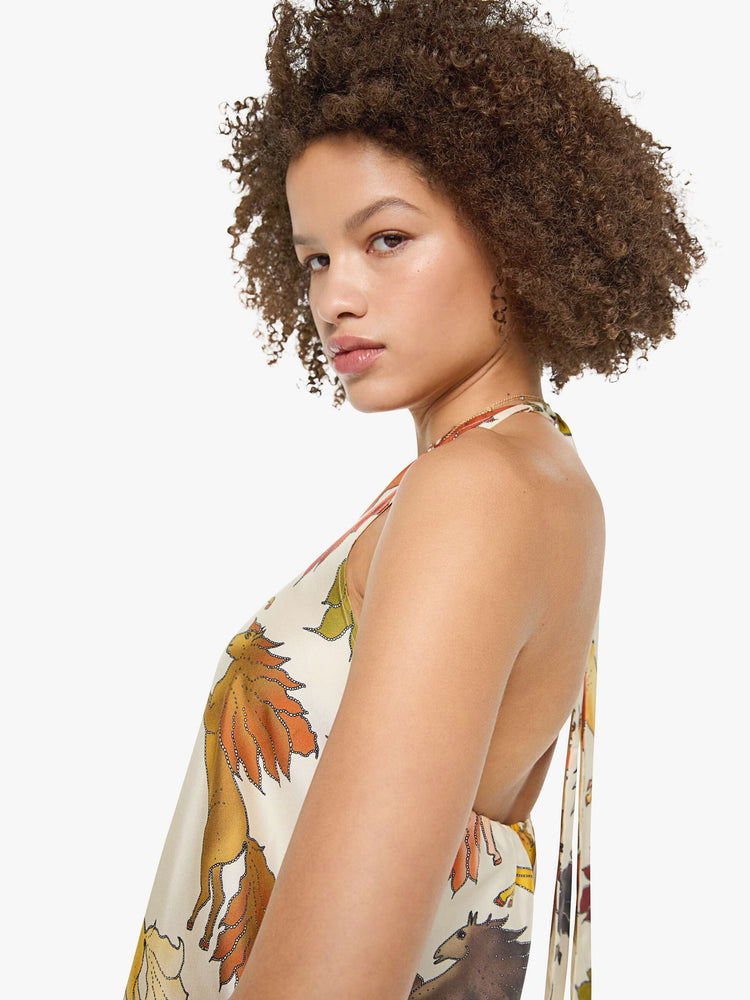 Close up view of a woman in prints with classic silhouettes, featuring a high halter neck, semi-fitted waist and a flowy ankle-length skirt