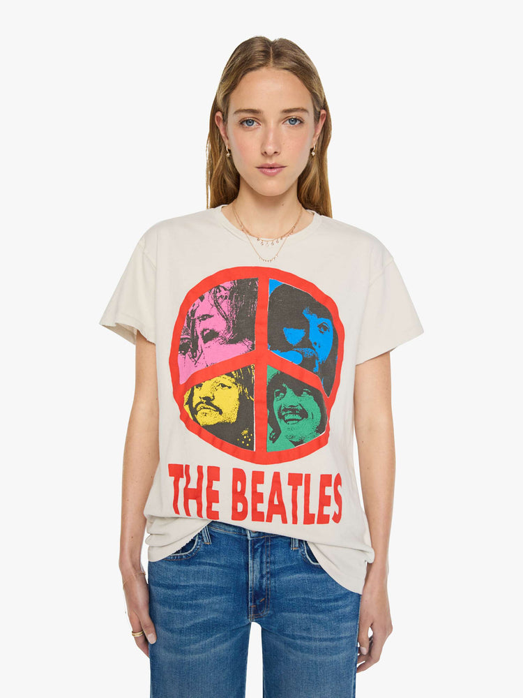 Front view of a woman in vintage white tee pays homage to The Beatles with a red peace sign and graphic portraits on the front.