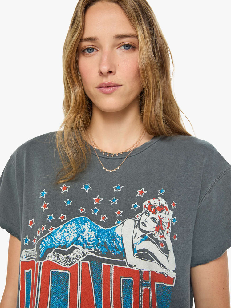 Close up view of a woman in a faded black  tee pays homage to Blondie with a colorful graphic and the band's name in red on the front.