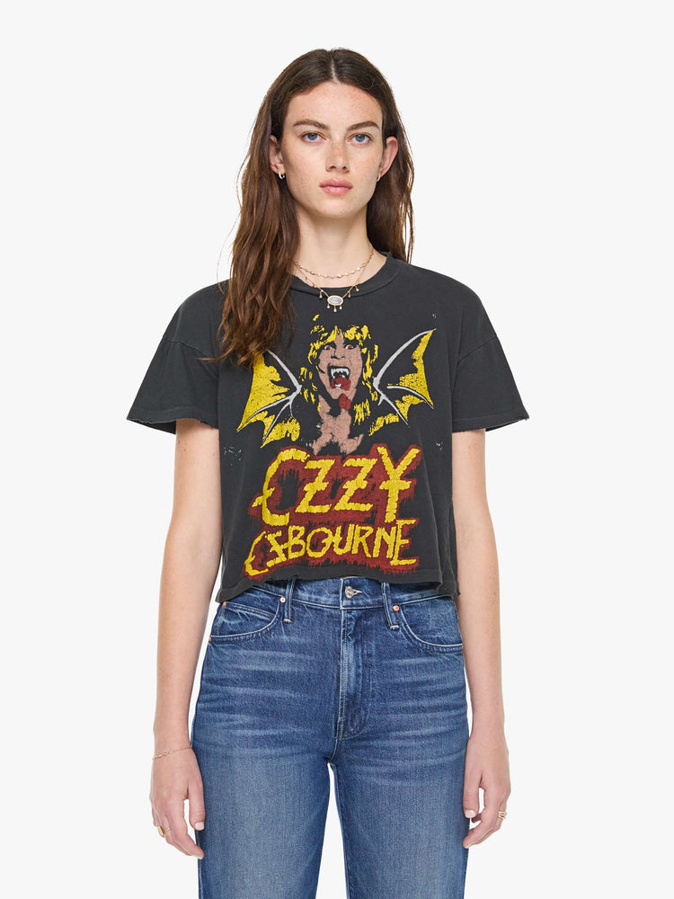 Front view of a woman in a black tee pays homage to Ozzy Osbourne with a colorful graphic and text in red and yellow on the front.