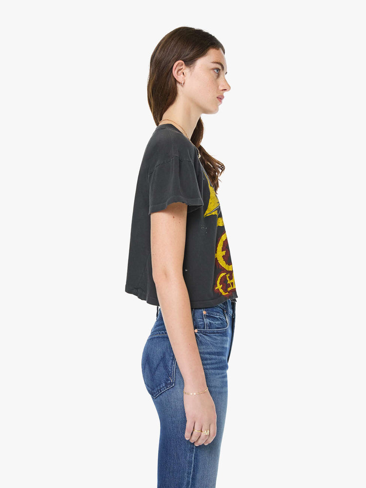 Side view of a woman in a black tee pays homage to Ozzy Osbourne with a colorful graphic and text in red and yellow on the front.