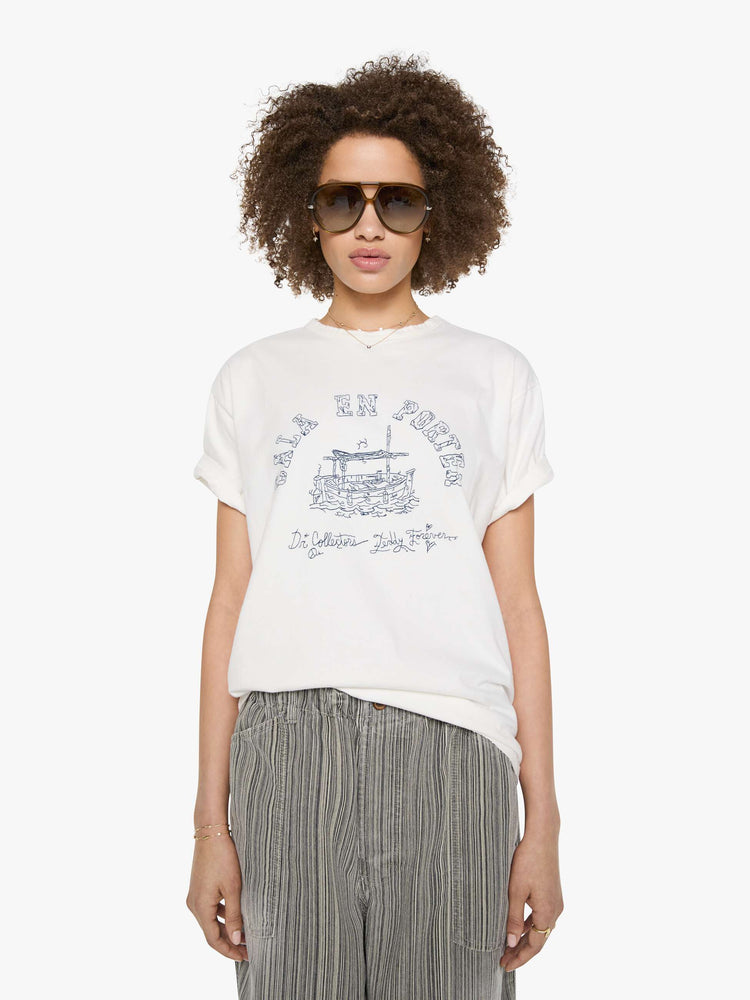 Front view of a woman in a white tee with a scene from Menorca, Spain, in faded blue.