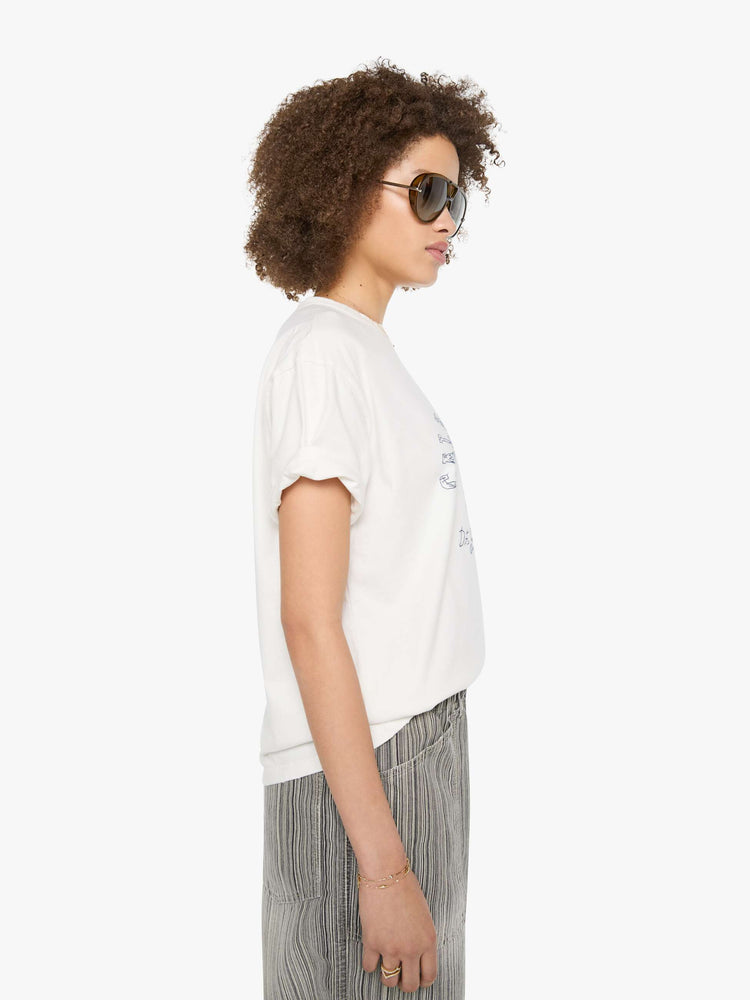 Side view of a woman in a white tee with a scene from Menorca, Spain, in faded blue.