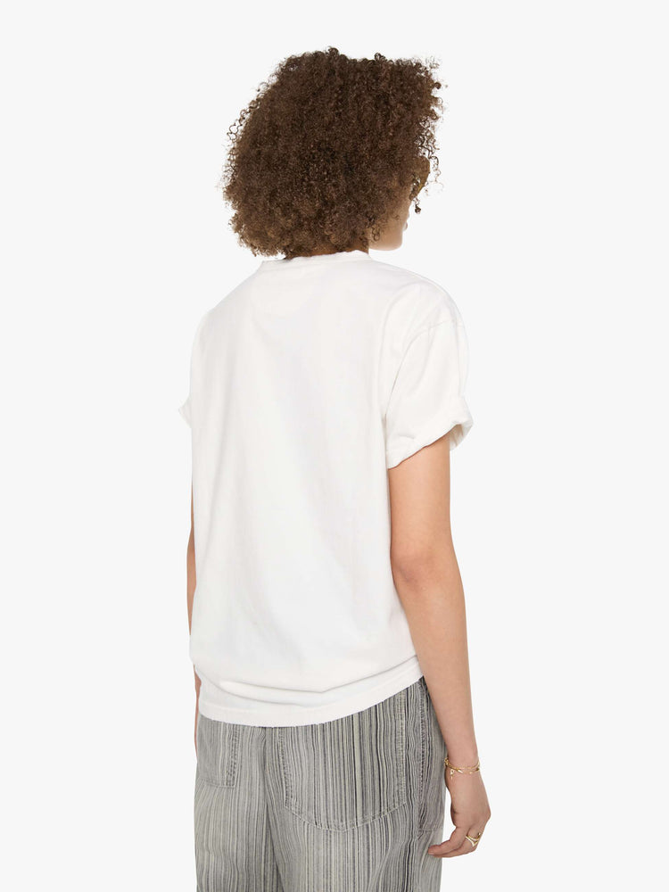 Back view of a woman in a white tee with a scene from Menorca, Spain, in faded blue.