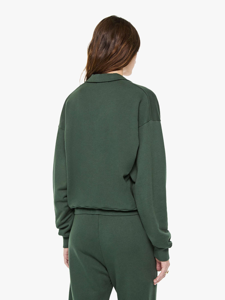 Back view of a woman in a forest green polo sweatshirt with a buttoned V-neck, drop shoulders, long sleeves and a cropped fit.