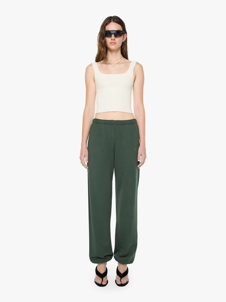 Front view of a woman in forest green sweatpants are designed with an elastic waistband and hems, slit pockets and a loose, comfortable fit.
