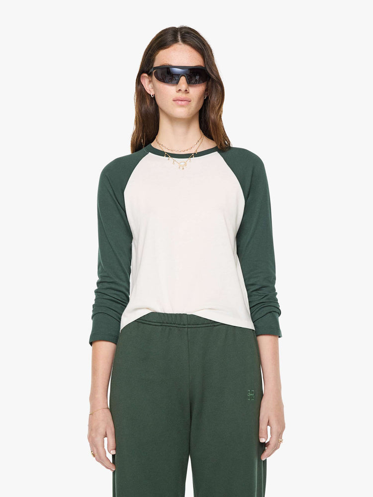 Front view of a woman in white with forest green sleeves and trim tee is designed with a crew neck, long sleeves and a narrow, slightly cropped fit.