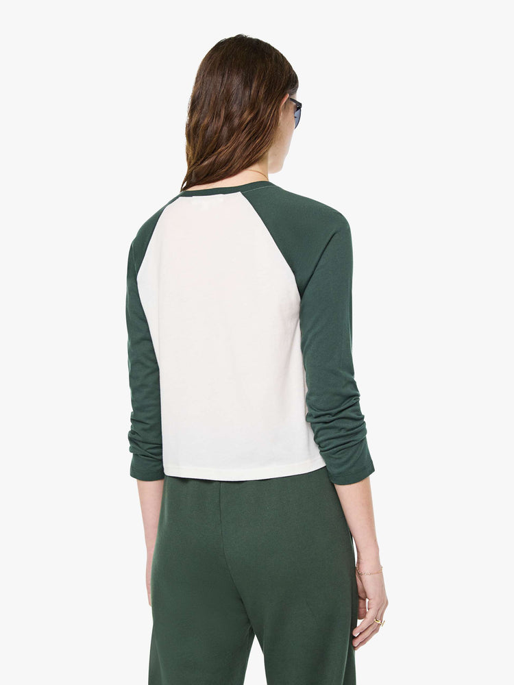 Back view of a woman in white with forest green sleeves and trim tee is designed with a crew neck, long sleeves and a narrow, slightly cropped fit.