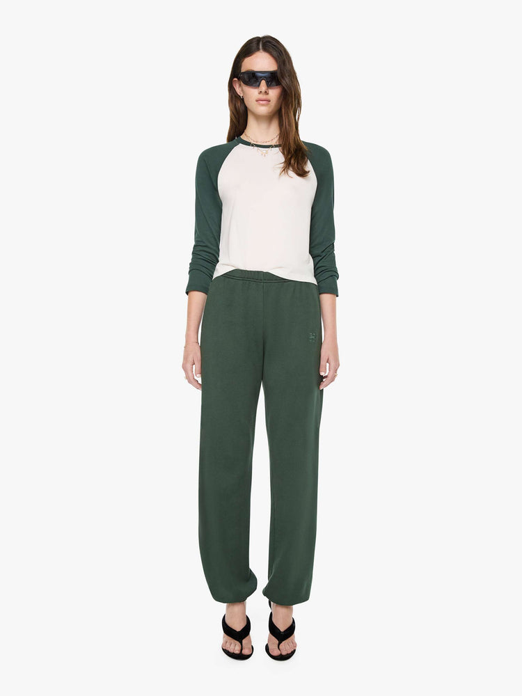 Full body view of a woman in white with forest green sleeves and trim tee is designed with a crew neck, long sleeves and a narrow, slightly cropped fit.