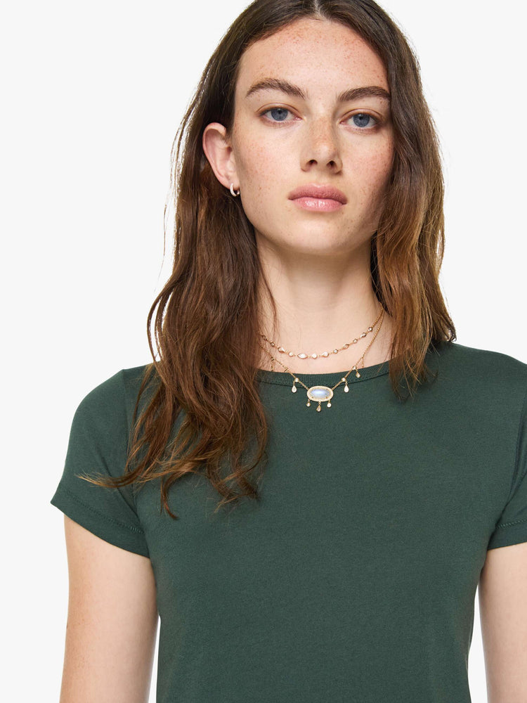 Close up view of a woman in a forest green crewneck tee is designed with short sleeves and a narrow fit.
