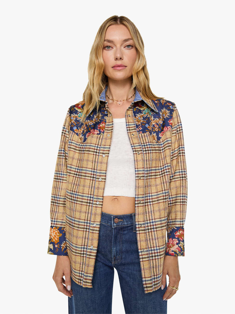 Front view of a woman in a jacket is made from 100% wool in yellow and blue plaid with floral-print panels at the chest and wrists, and features a collared neck and slightly dropped shoulders.