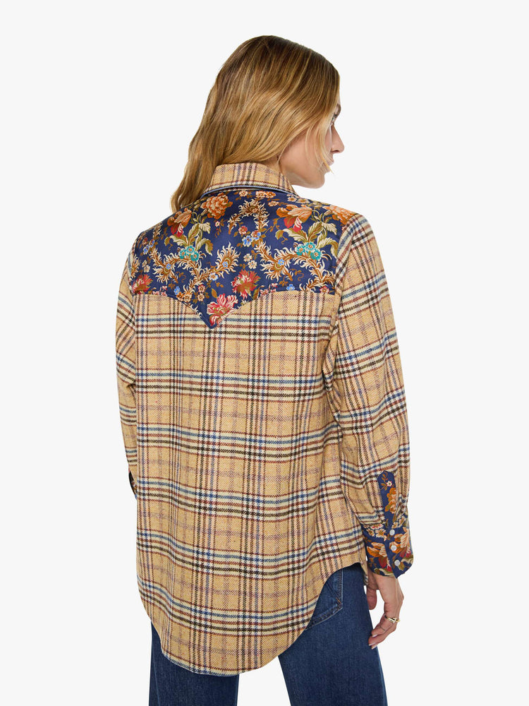 Back view of a woman in a jacket is made from 100% wool in yellow and blue plaid with floral-print panels at the chest and wrists, and features a collared neck and slightly dropped shoulders.